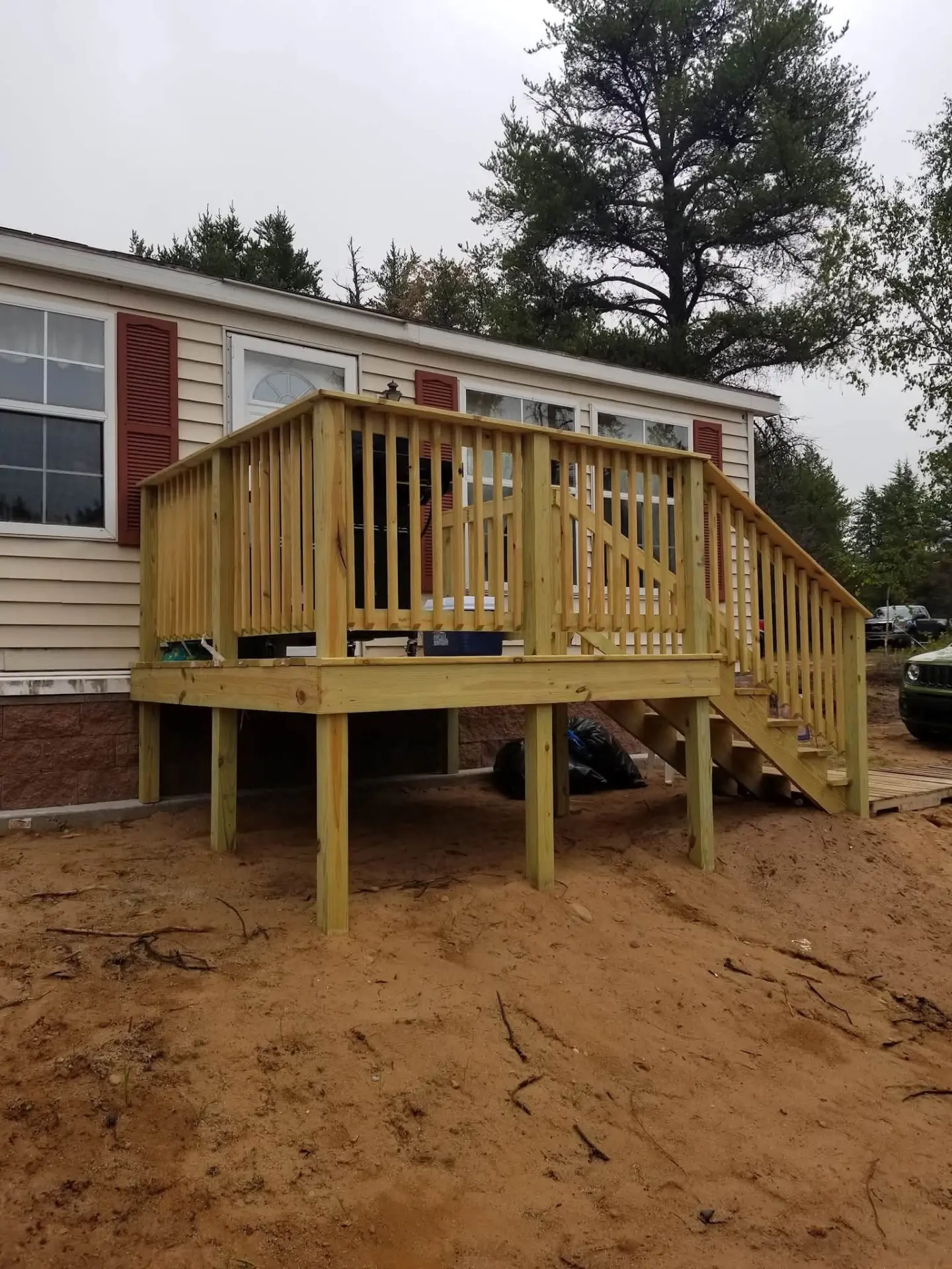 New wooden deck with railings and stairs on a home