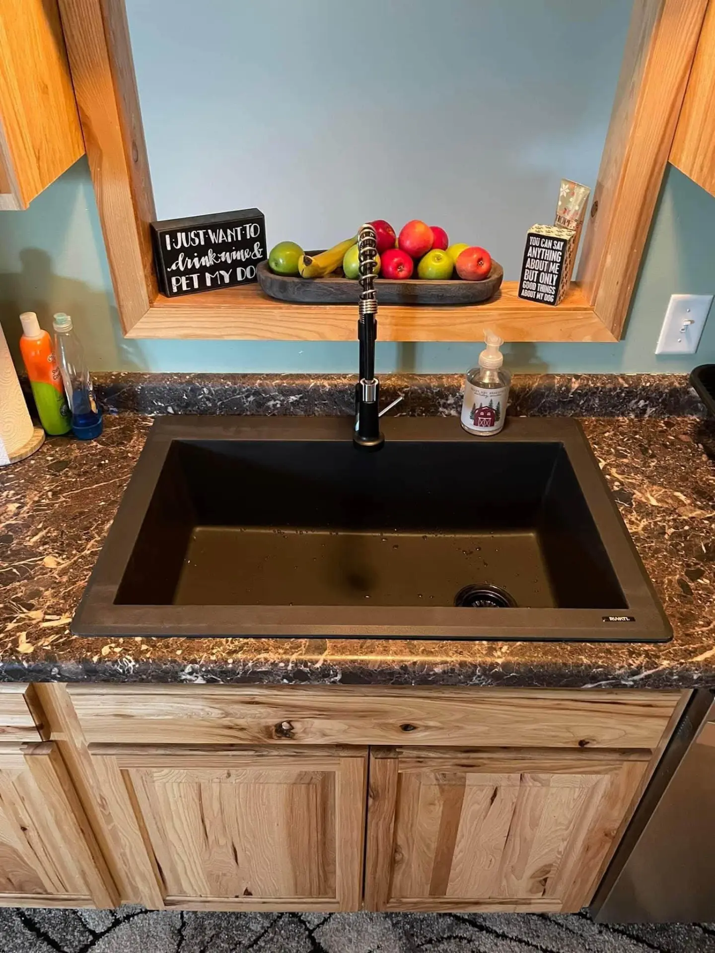 Kitchen counter with dark sink, faucet, cabinets and open shelving